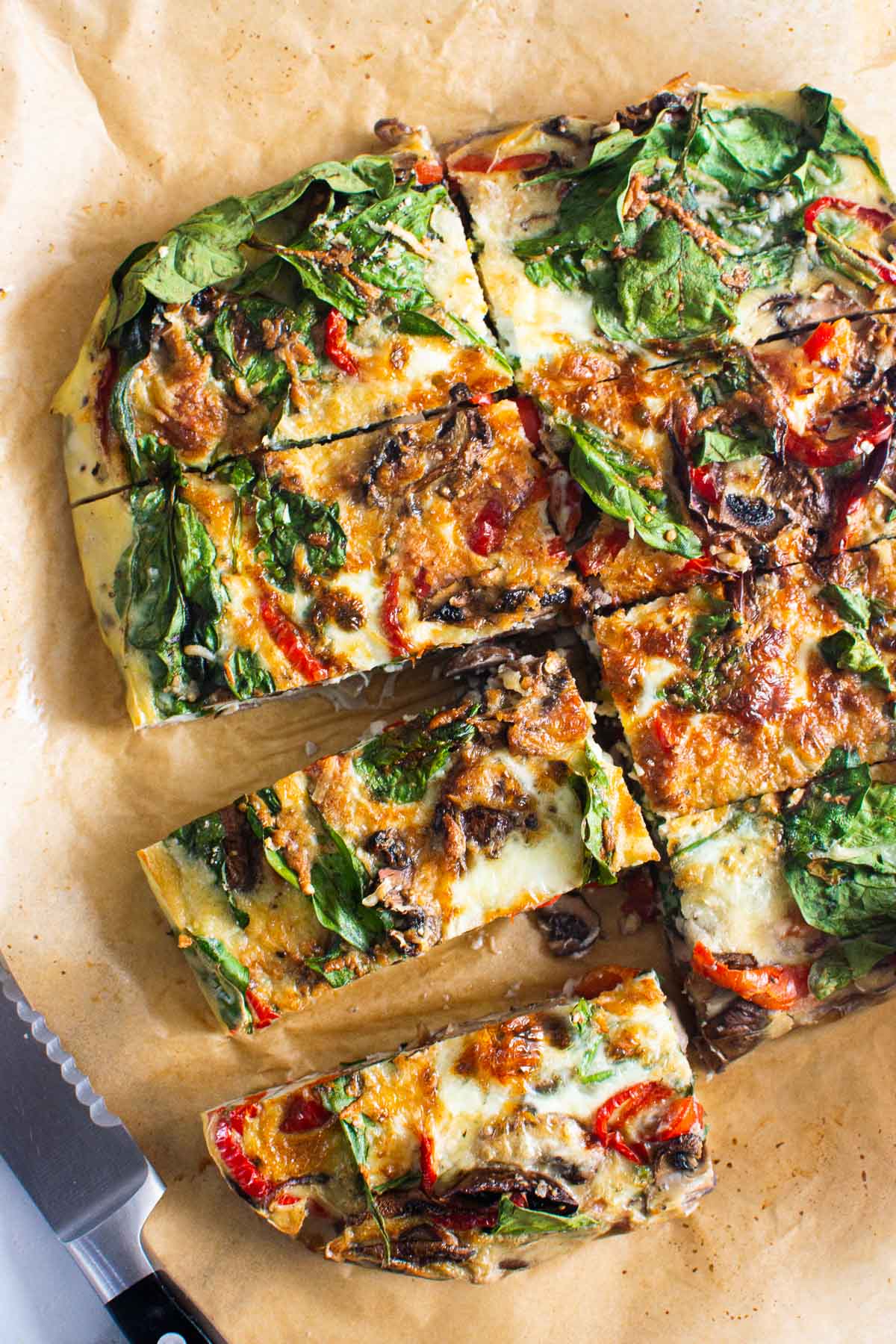 Air fryer breakfast casserole cut into slices on parchment paper.