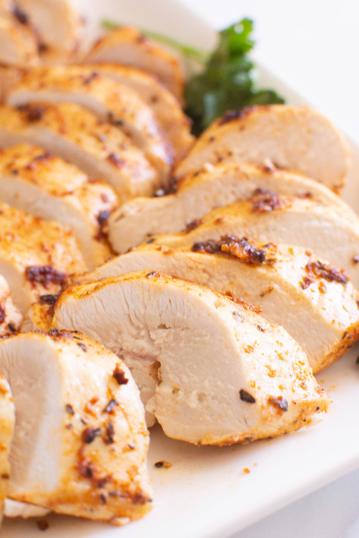 Close up of sliced air fryer chicken breast on a plate.