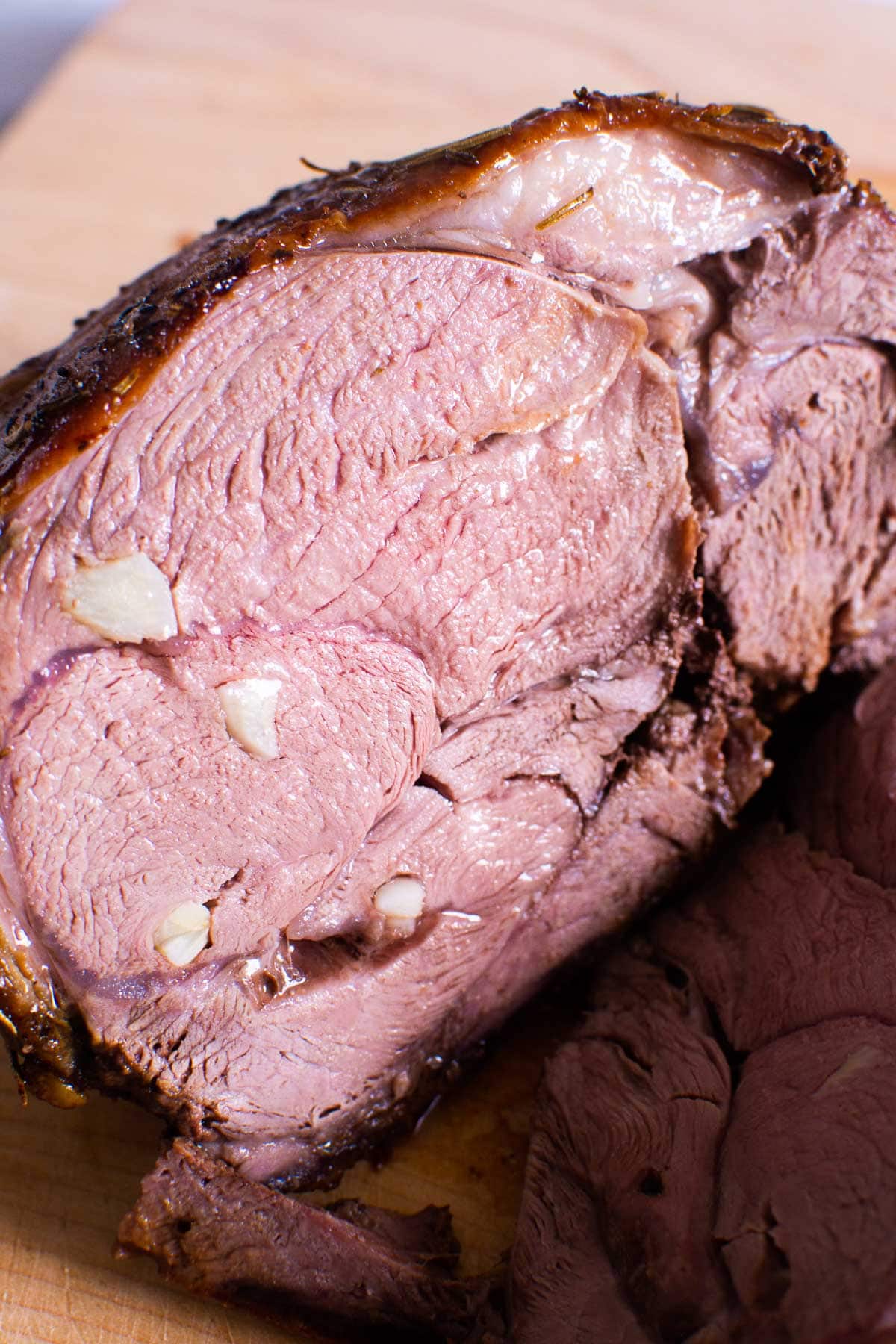 Closeup of sliced stuffed with garlic boneless leg of lamb.