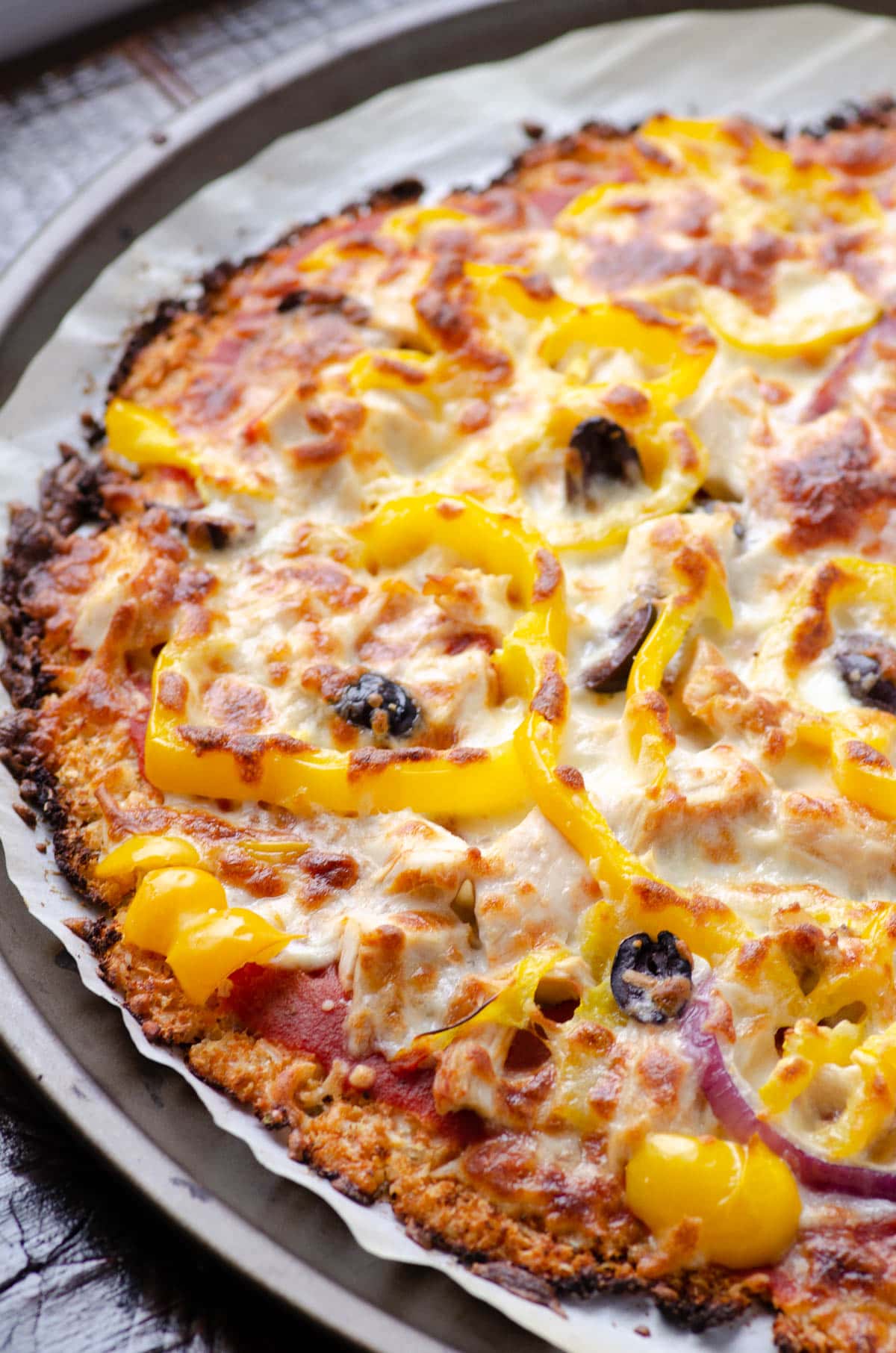 Cauliflower pizza crust with bell pepper, olives, red onion and cheese.