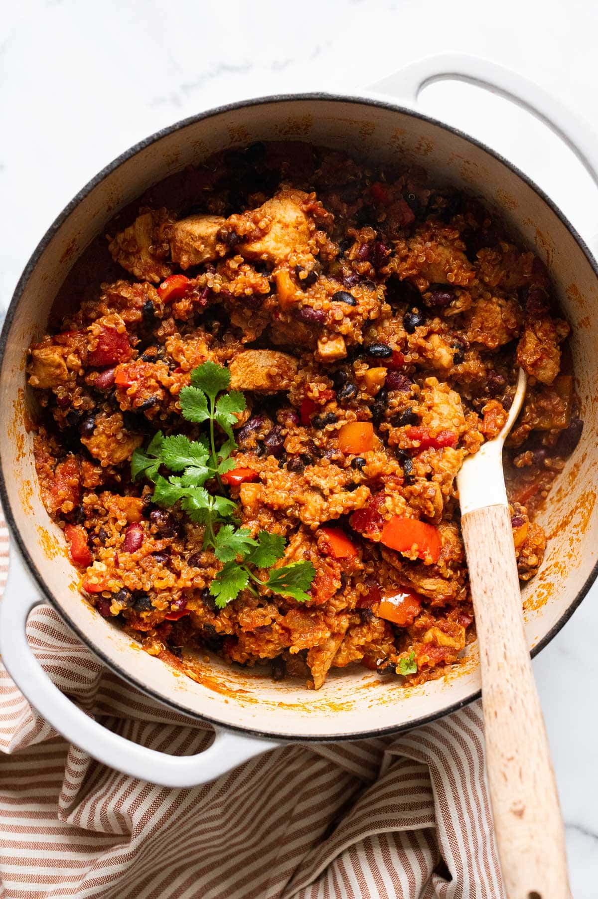 Chicken quinoa chili in a pot with spoon.