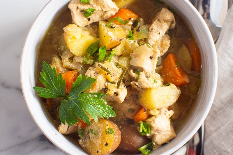 Chicken stew in a bowl with fresh parsley.