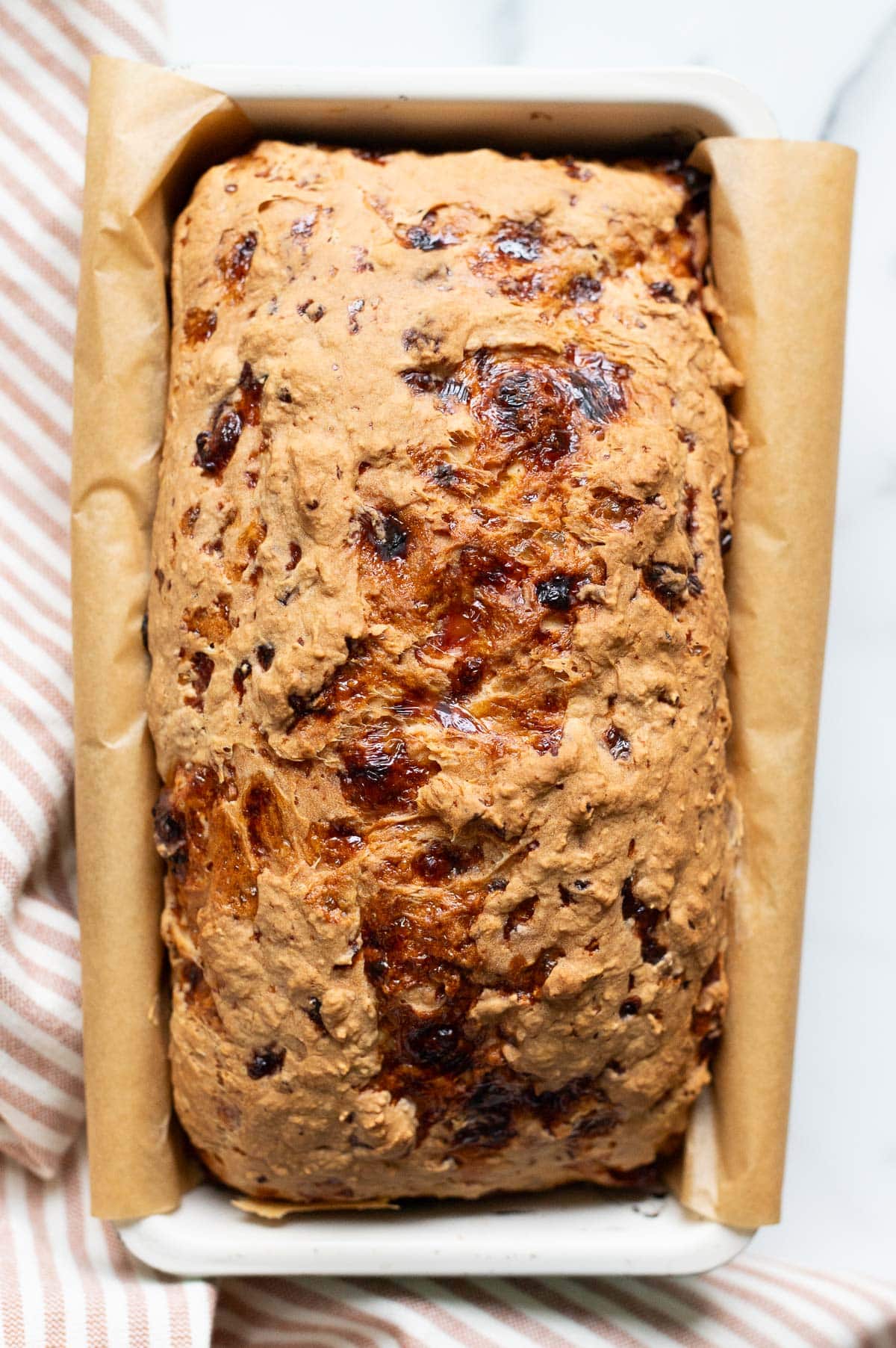 Cottage cheese bread in a loaf pan and linen towel.