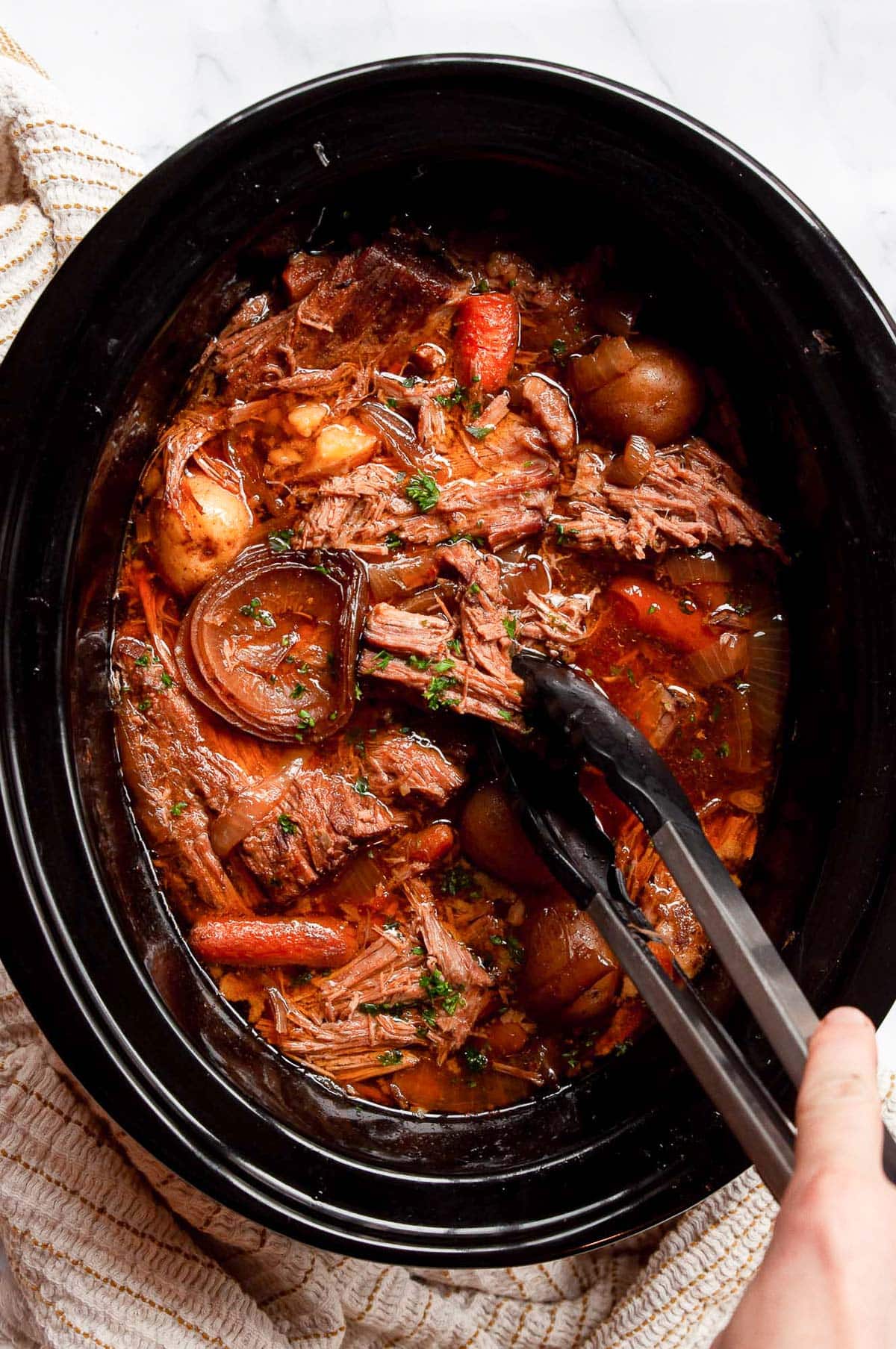 Crock pot sirloin tip roast with baby potatoes and carrots in gravy.