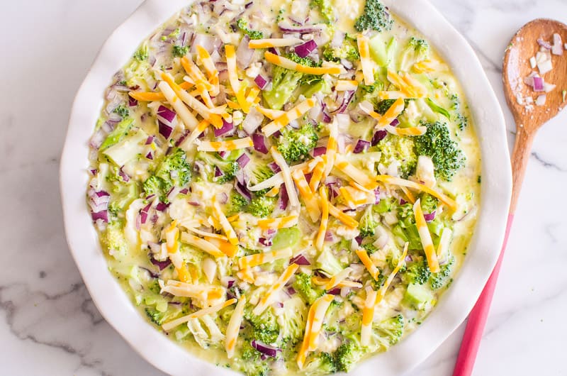 Crustless Broccoli Quiche assembled and ready to bake in a pie dish