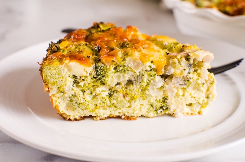Crustless broccoli quiche slice on a white plate and with black fork.