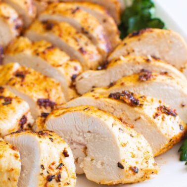Sliced air fryer chicken breast on a plate.