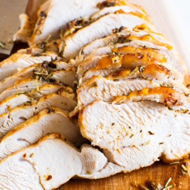 Sliced air fryer turkey breast on a cutting board with a knife.