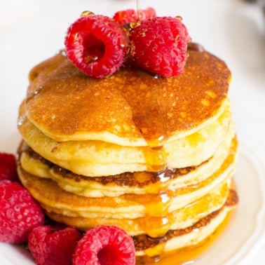 almond flour pancakes with maple syrup and raspberries