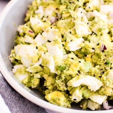 Avocado egg salad in a bowl with black pepper garnish.