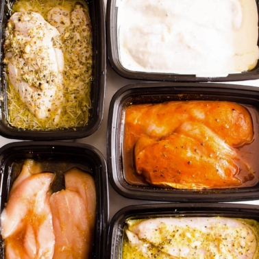 Five containers with chicken breasts marinated in various chicken marinades.