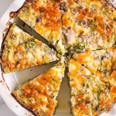 Sliced crustless broccoli quiche in a pie dish.