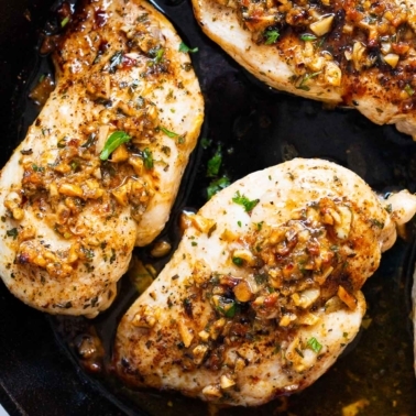 Garlic butter chicken breasts in sauce in skillet.