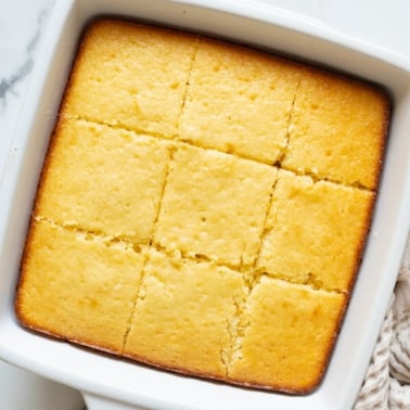 Sliced Greek yogurt cake in a square baking dish.