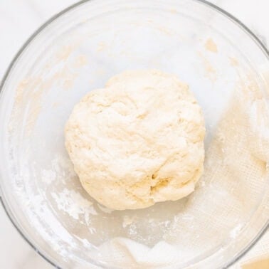 Greek yogurt pizza dough in a glass bowl.