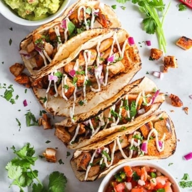 Chicken street tacos wrapped in tortillas with cilantro and guacamole.