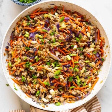 Egg roll in a bowl in a skillet.