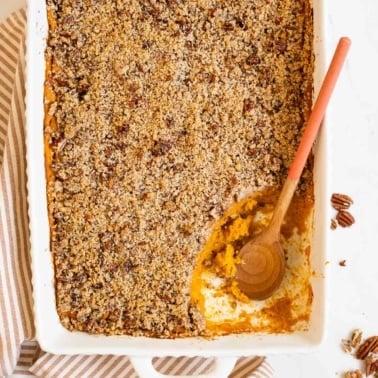 Healthy sweet potato casserole with a wooden spoon in baking dish.