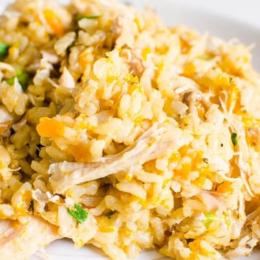 Instant pot chicken and rice garnished with parsley on a plate.