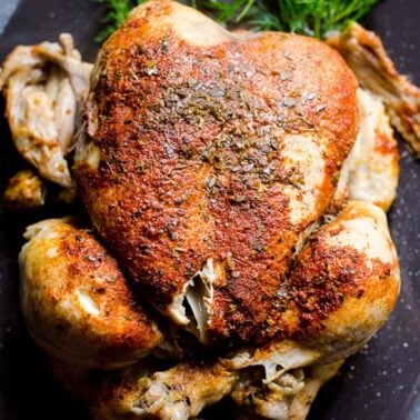 Instant pot frozen chicken on a gray platter with dill.
