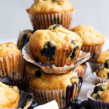 Lemon blueberry muffins stacked on top of which other.
