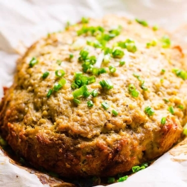 Cooked slow cooker turkey meatloaf on parchment paper garnished with green onion.