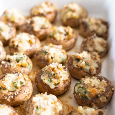 Stuffed mushroom caps in a baking dish.