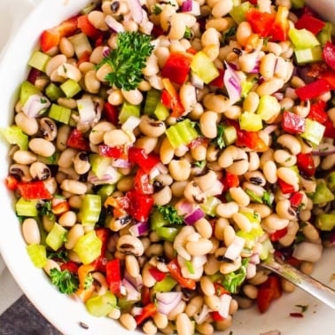 White bean salad in a bowl with a spoon.