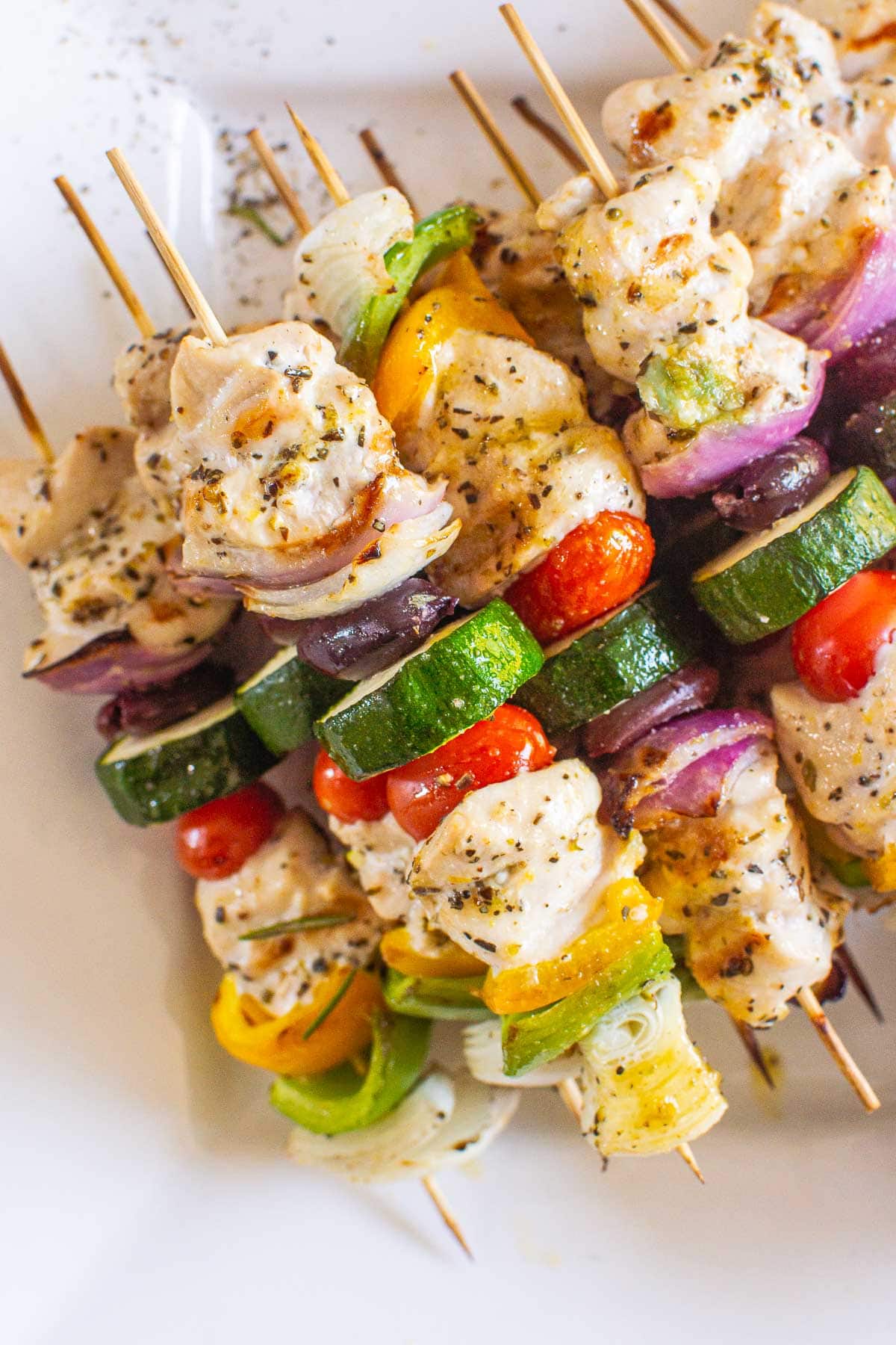 Grilled Greek chicken kabobs with vegetables on skewers.