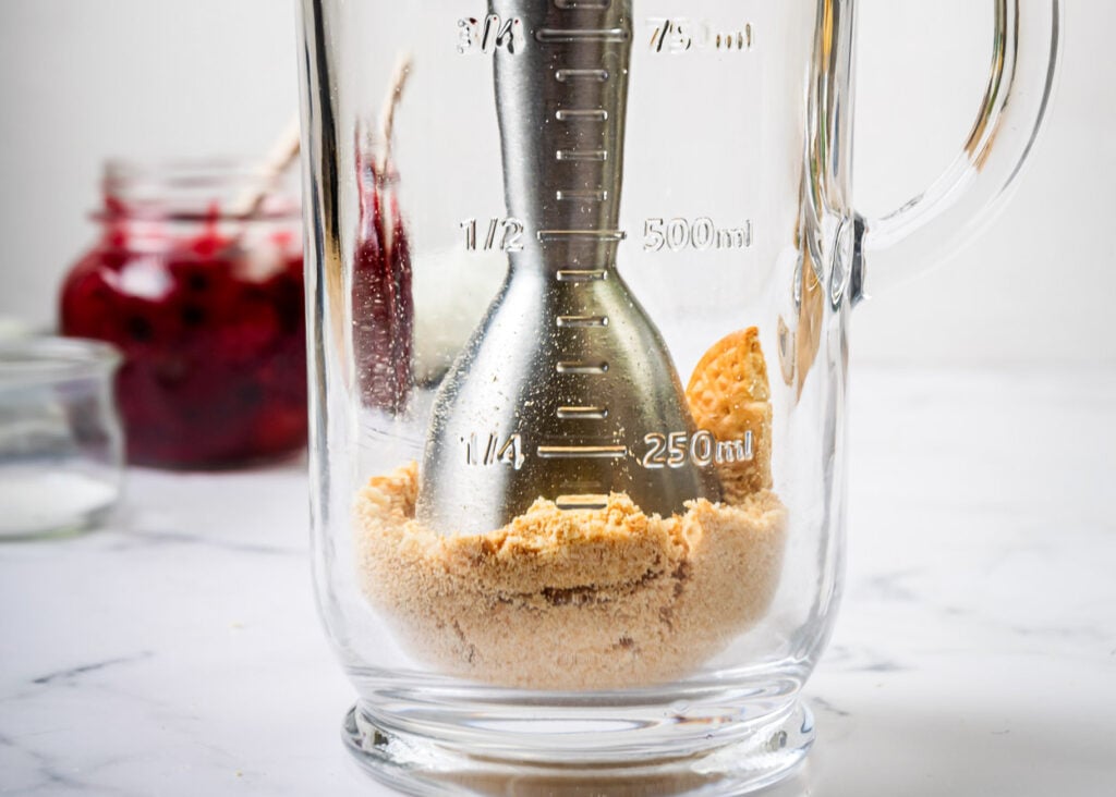 Crushing graham crackers into crumbs with immersion blender.