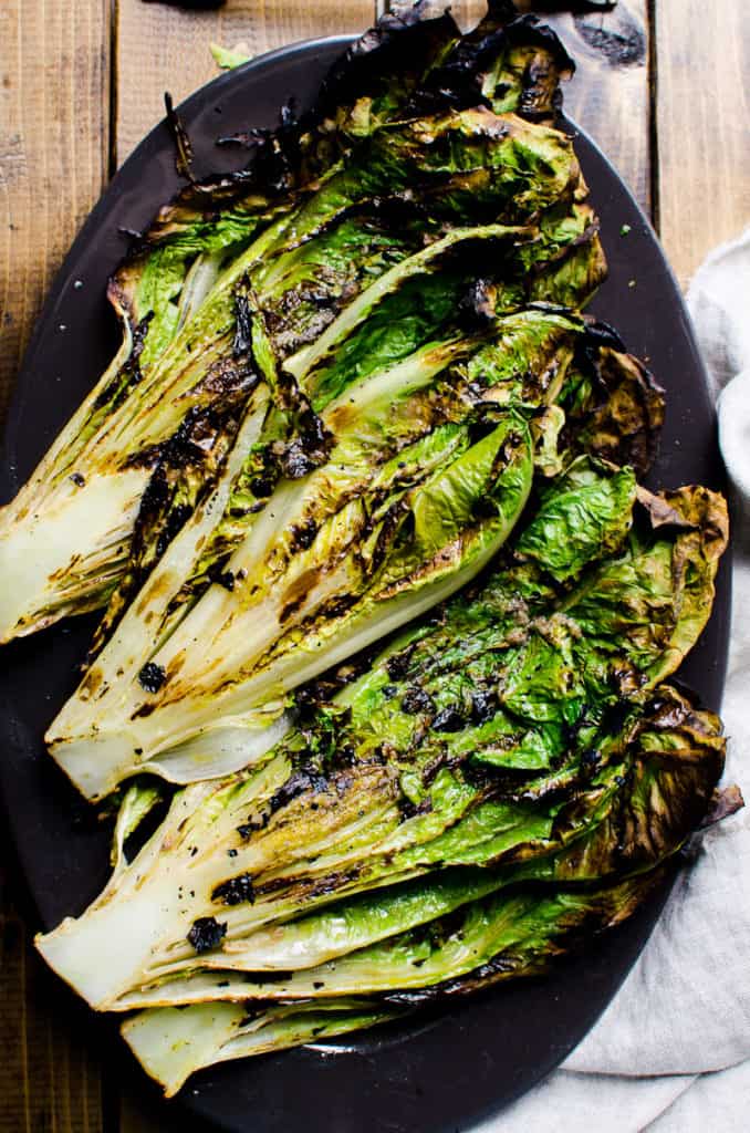 grilled romaine lettuce on black platter
