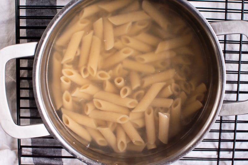 Cooked pasta al dente in a pot on wire rack.