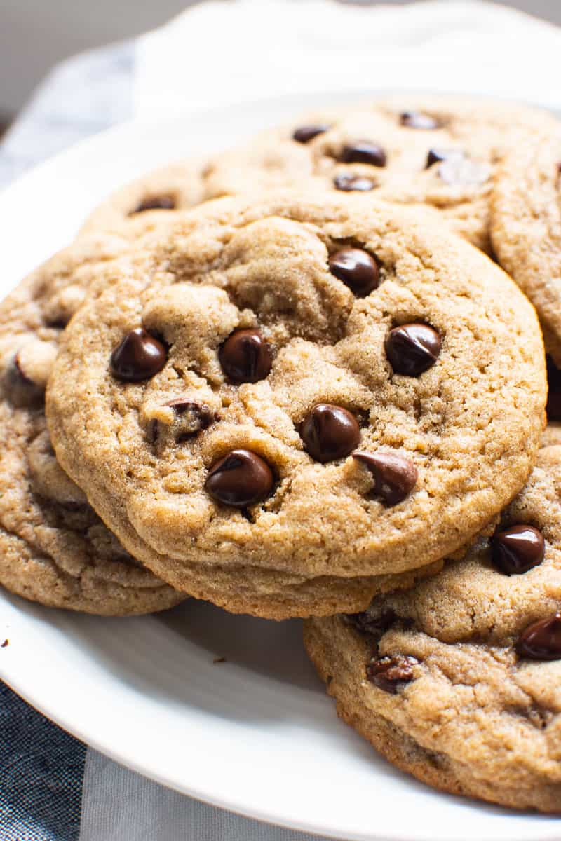Healthy chocolate chip cookies stacked on white plate.