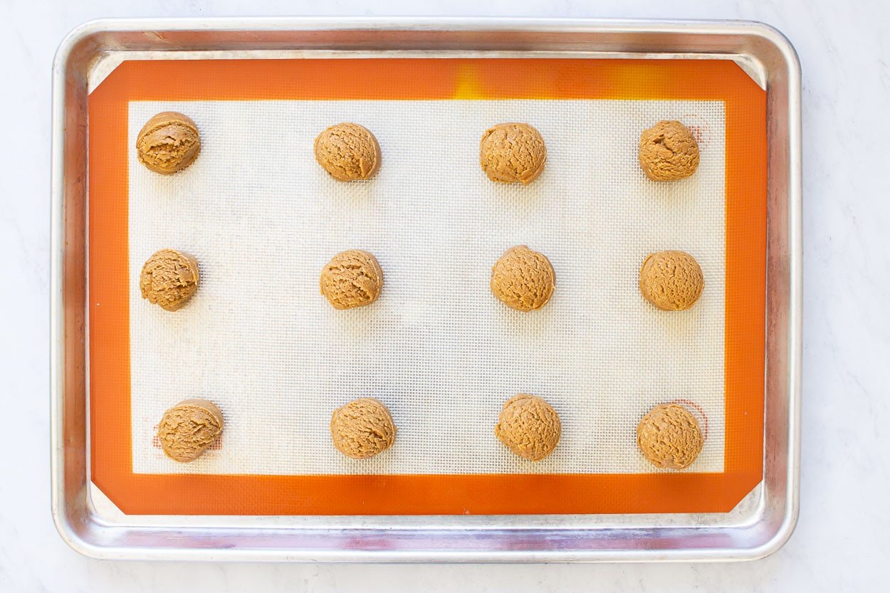 Balls of cookie dough on baking sheet.