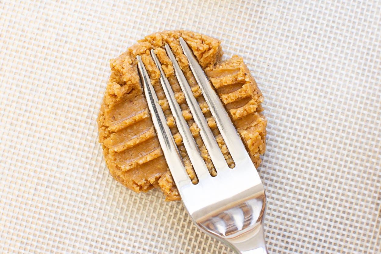 Making criss cross pattern with a fork on a cookie.