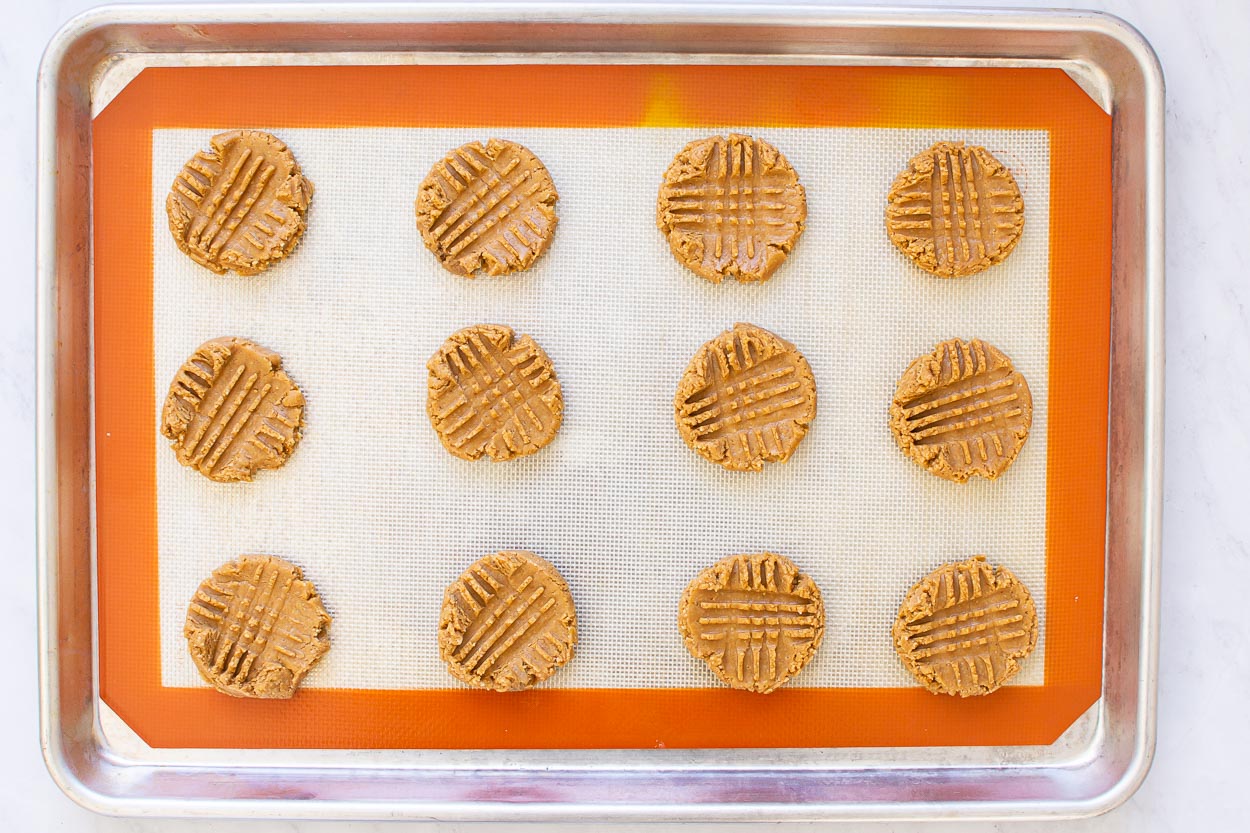 Peanut butter cookies on a baking sheet ready to bake.