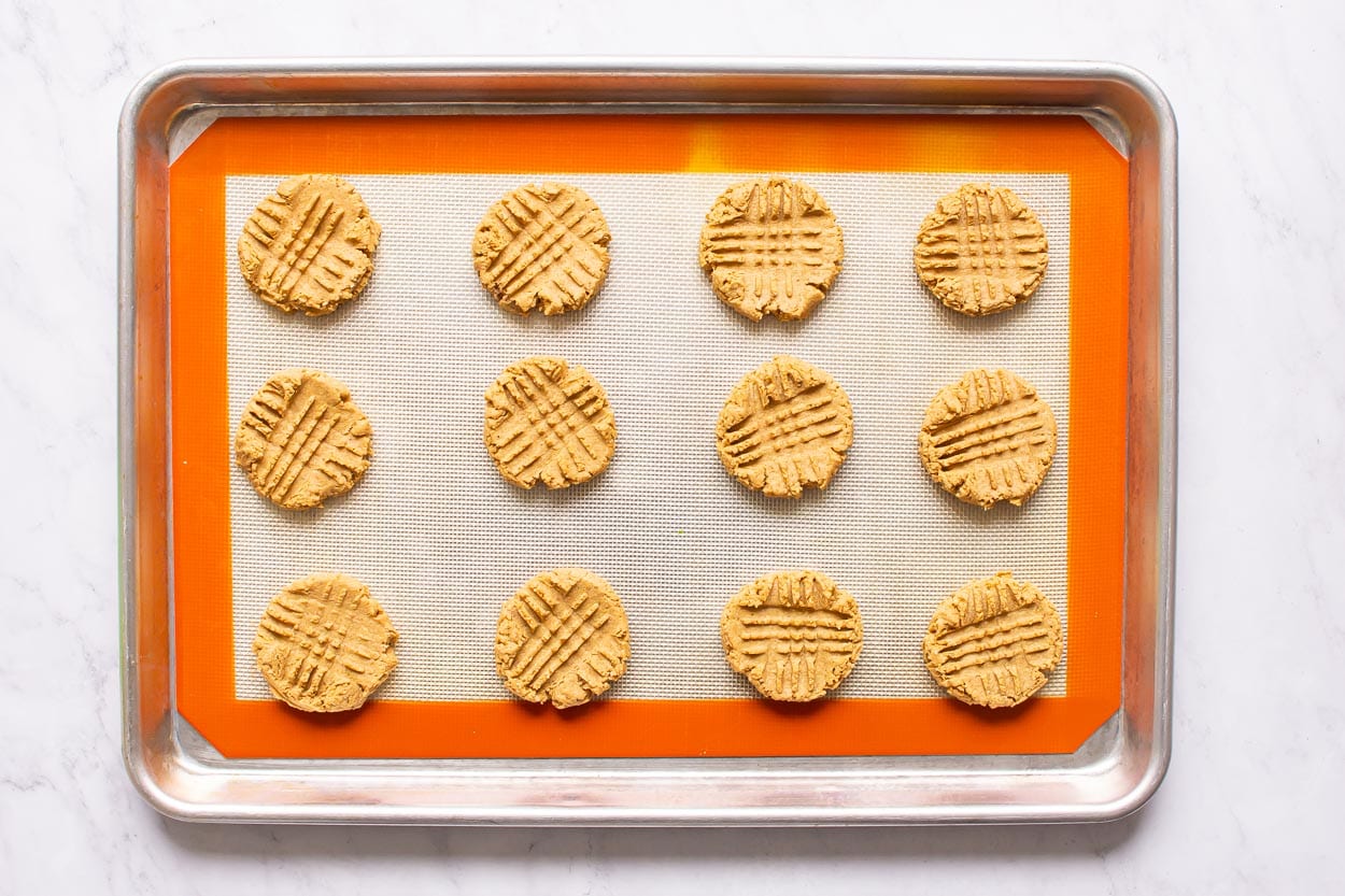 Baked and cooled peanut butter cookies on a baking sheet.
