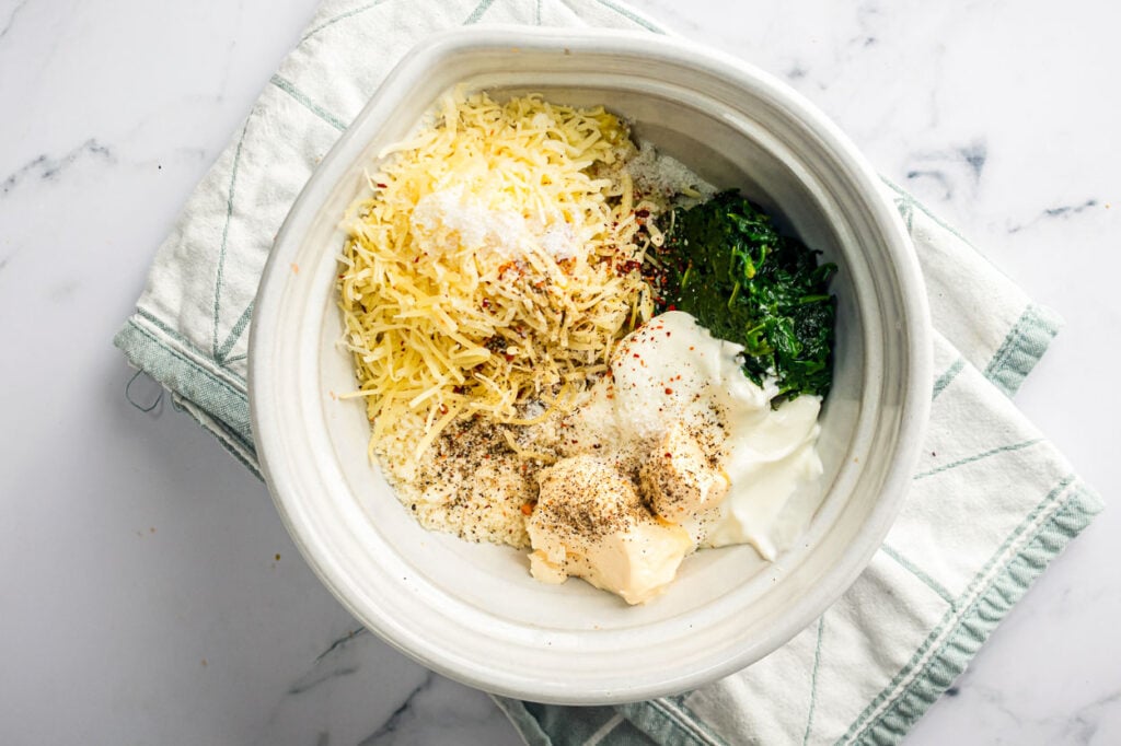 Cheese, spinach, mayo, yogurt and spices in a bowl.