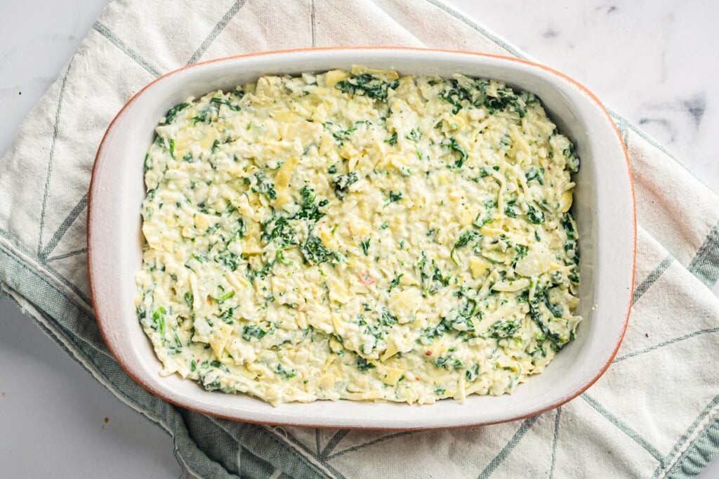Healthy spinach artichoke dip in baking dish before baking.