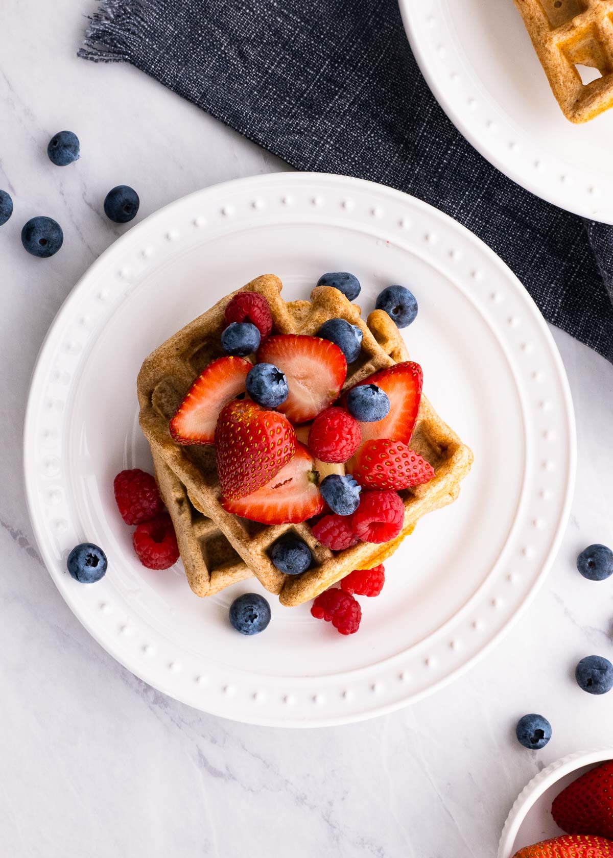 Healthy waffles on a plate with fresh berries.