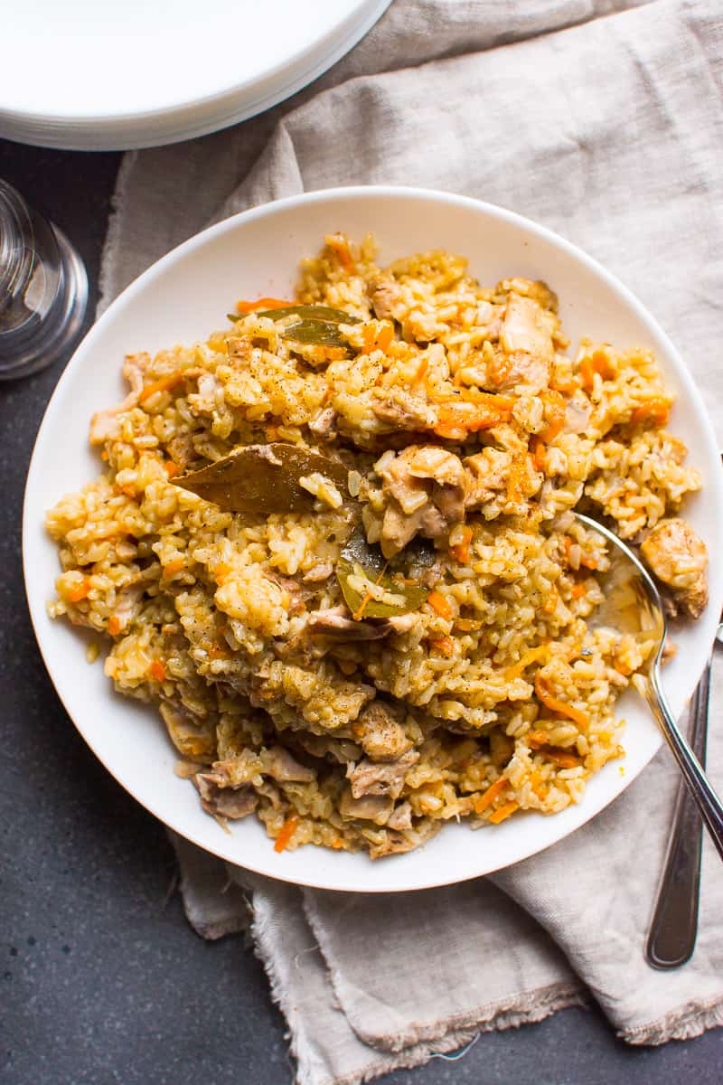Instant Pot chicken and rice served on white plate with a spoon.