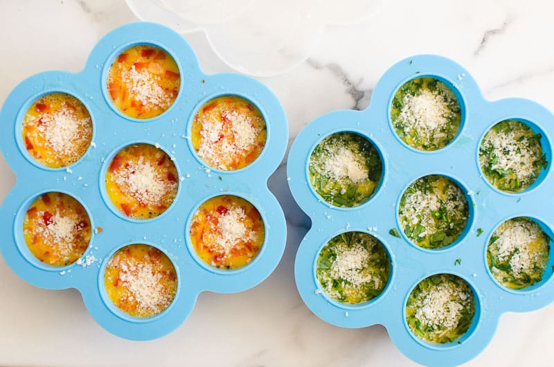 Two egg bite molds filled with egg mixture.