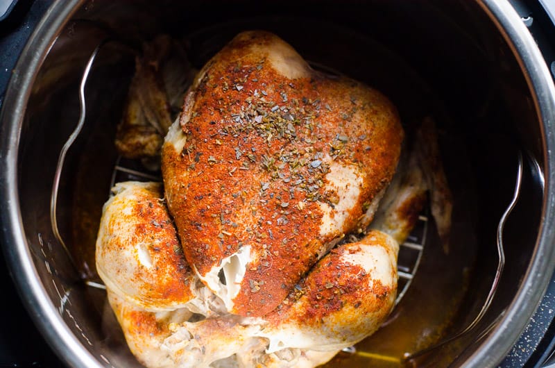 Cooked whole frozen chicken in Instant Pot on a trivet.