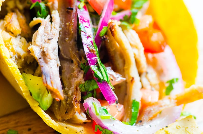 Instant Pot carnitas on tortilla with onions, tomatoes and avocado