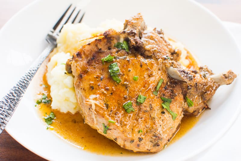 instant pot pork chops garnished with parsley and served with mashed potatoes