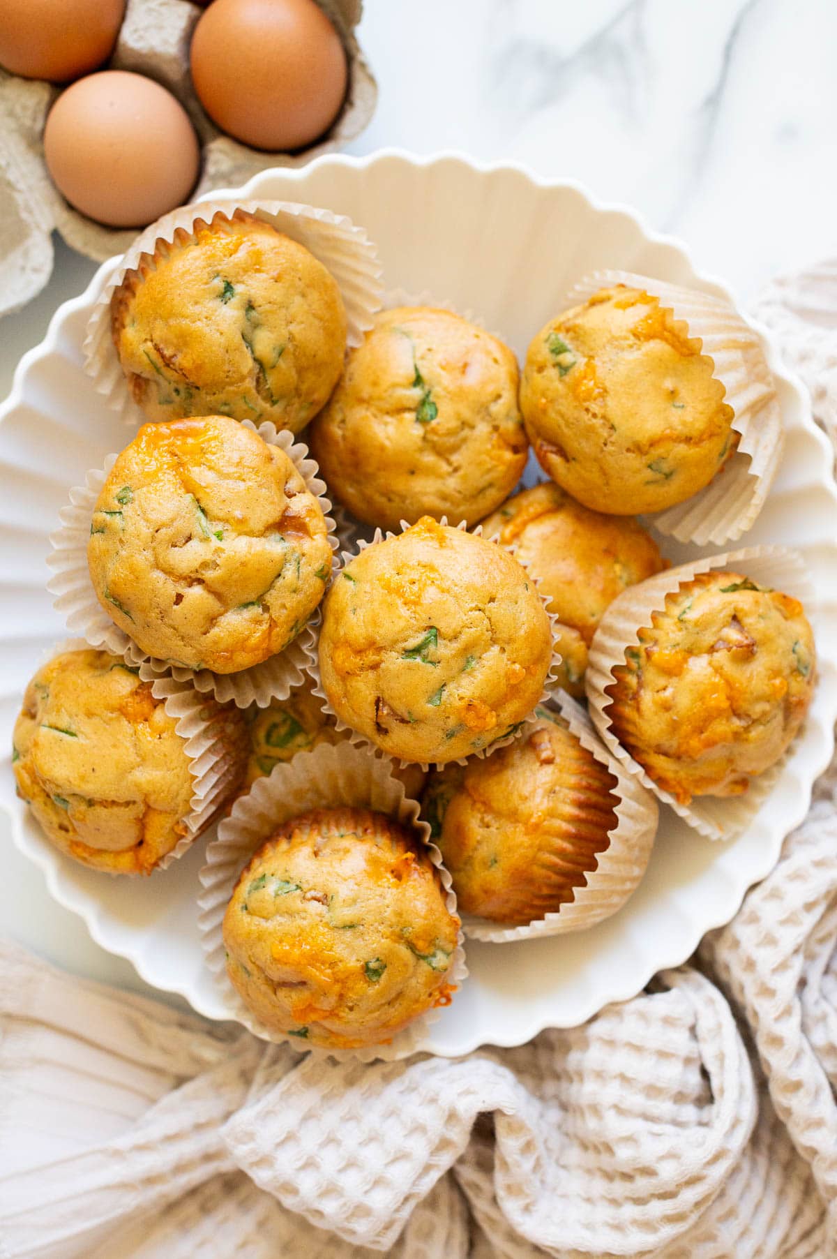 Sausage pancake muffins in liners served in a bowl.