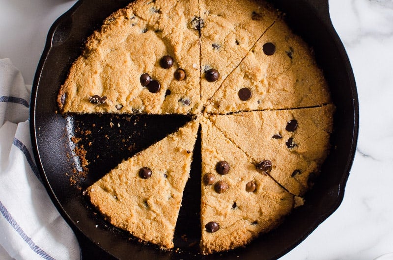Sliced skillet cookie in cast iron skillet.