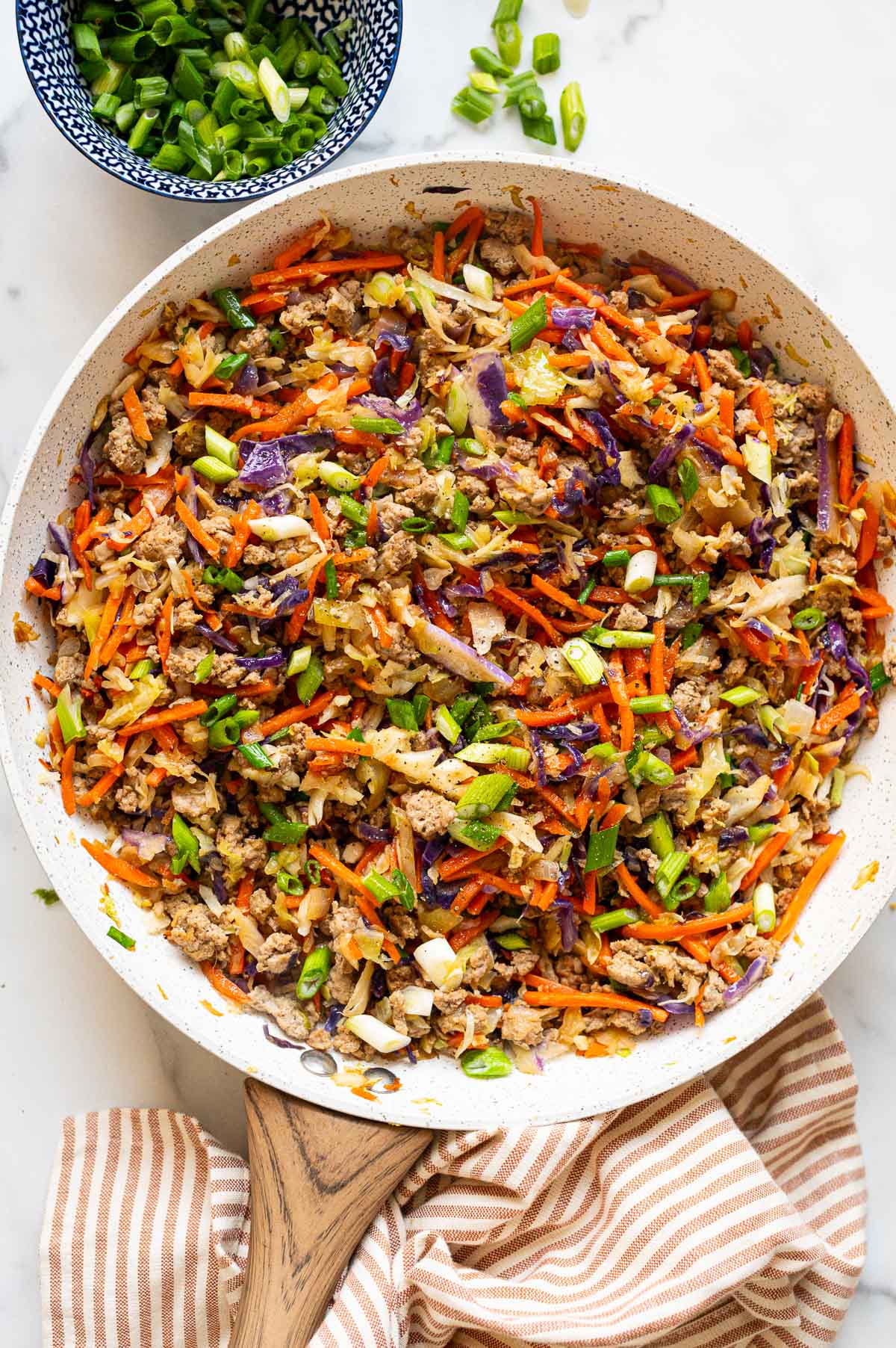 Egg roll in a bowl in a skillet.