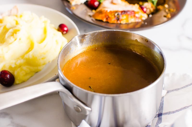 turkey gravy in a stainless steel measuring cup