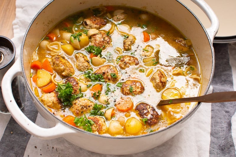 A pot with turkey meatball soup and ladle in it.